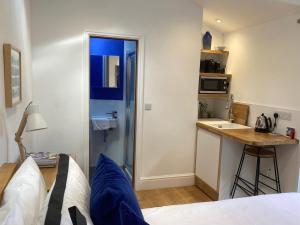a room with a bed and a kitchen with a counter at The Little Studio in Penzance