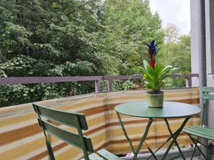 a table and chairs on a balcony with a plant at City Appartement am Olympiapark in Munich