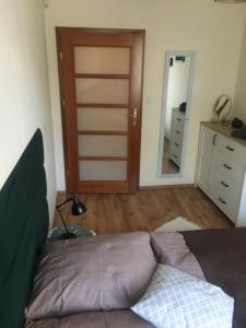 a bedroom with a bed and a door with a mirror at Apartament M in Polanica-Zdrój