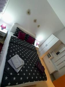 sypialnia z czarno-białym łóżkiem z gwiazdami w obiekcie Lux Snezana w mieście Vrdnik
