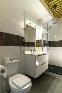 ein Badezimmer mit einem WC, einem Waschbecken und einem Spiegel in der Unterkunft Hôtel du Midi in Domène