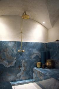 bagno con parete piastrellata blu e soffitto di Perlekech Riad & Spa a Marrakech
