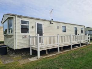 a mobile home with a porch and a fence at 8 berth central heated on Coral Beach ABI CB in Ingoldmells