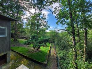 a view of a yard with trees and a train track at Chalet Noisette in Durbuy