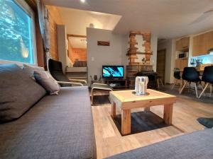 a living room with a couch and a table at Chalet Noisette in Durbuy