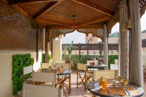 an outdoor dining area with tables and chairs at Perlekech Riad & Spa in Marrakech