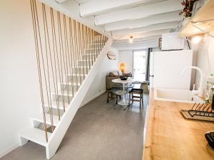 a kitchen and dining room with a staircase in a house at Little Casa Royan in Royan