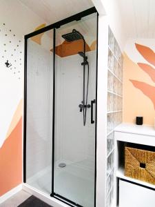 La salle de bains est pourvue d'une douche avec une porte en verre. dans l'établissement Little Casa Royan, à Royan