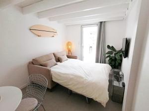 a bedroom with a bed and a couch and a window at Little Casa Royan in Royan