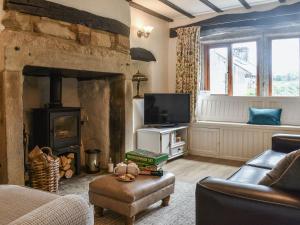 a living room with a fireplace and a tv at Lodge Farm Cottage in Haworth