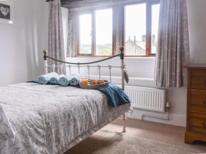 Un dormitorio con una cama con una bandeja de comida. en Lodge Farm Cottage en Haworth