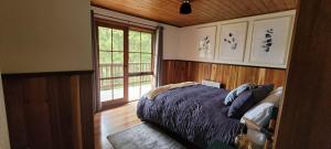 a bedroom with a bed and a large window at Tall Trees Eco Retreat in Apollo Bay
