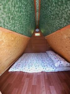 Piratas Cabanas Camping Bar في باراتي: سرير صغير في زاوية منزل صغير
