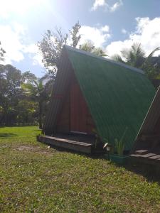 una piccola casa con un tetto verde sull'erba di Piratas Cabanas Camping Bar a Parati