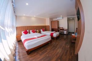 ein Hotelzimmer mit 2 Betten und einem Tisch in der Unterkunft Hotel Chhimeki in Kathmandu