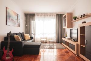 a living room with a black couch and a guitar at Apartmento Alcabre (Vigo) vistas al mar 6 personas in Vigo