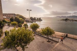 a man walking on a sidewalk next to a body of water at Apartmento Alcabre (Vigo) vistas al mar 6 personas in Vigo