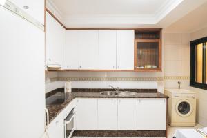 a white kitchen with a sink and a washing machine at Apartmento Alcabre (Vigo) vistas al mar 6 personas in Vigo