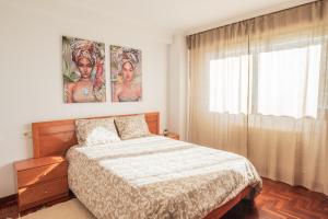 a bedroom with a bed and a large window at Apartmento Alcabre (Vigo) vistas al mar 6 personas in Vigo