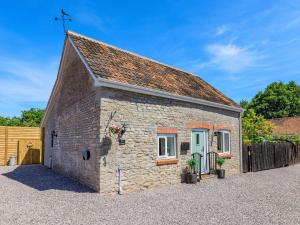 un piccolo cottage in pietra con una porta blu di Pea Cottage a Ilchester