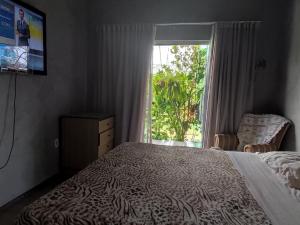 a bedroom with a bed and a large window at Casa do Sossego in Brasilia