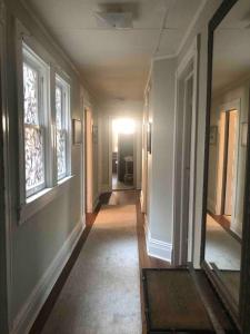 an empty hallway of a house with windows at Redefined Alchemy - Bright, eclectic, pretty Apt 3E in Little Falls