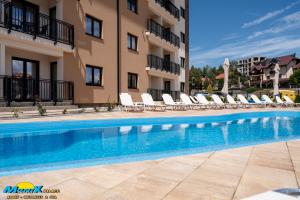 a swimming pool in front of a building at Monix Palace Zlatibor in Zlatibor