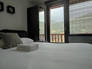 a bedroom with a large white bed and a window at AC Apartaments Bordes in Bordes d´Envalira 