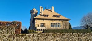 une maison avec une tourelle au-dessus d'un mur en pierre dans l'établissement Le Kalloé, à Thonon-les-Bains