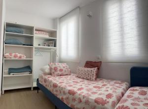 1 dormitorio con cama y estante para libros en MIRANDO AL MAR TENERIFE, en Candelaria
