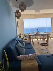 sala de estar con sofá azul y mesa en MIRANDO AL MAR TENERIFE, en Candelaria