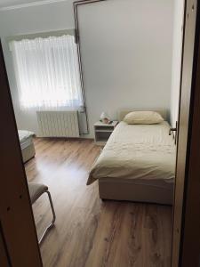 a bedroom with a bed and a window and a chair at House Burić in Otočac