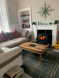 a living room with a couch and a coffee table at Superb Loch Side Apartment with Sea & Sunset Views in Helensburgh