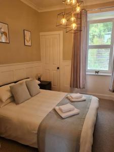 a bedroom with a large bed with two towels on it at Superb Loch Side Apartment with Sea & Sunset Views in Helensburgh