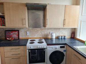 a kitchen with a stove and a counter top at Superb Loch Side Apartment with Sea & Sunset Views in Helensburgh