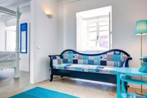 um sofá azul num quarto com uma janela em Casa do Largo Silves em Silves