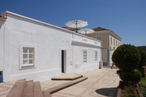 a white building with a door on the side of it at Casa do Largo Silves in Silves