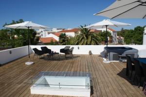 un patio con sedie, tavoli e ombrelloni di Casa do Largo Silves a Silves