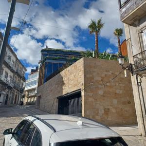 un coche blanco estacionado frente a un edificio en Loft Turístico, en Vigo
