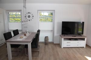 a dining room with a table and a television at Seepferdchen in Greetsiel