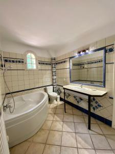 a bathroom with a tub and a toilet and a sink at Bastide de Gueissard in Saint-Cyr-sur-Mer