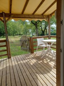 una terraza de madera con una mesa y una silla. en Logement entier wifi stationnement gratuit, en Voiron