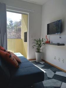 um quarto com uma cama e um vaso de plantas em Apartamento ao lado da Vila Germânica em Blumenau