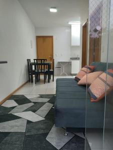 a living room with a couch and a table at Apartamento ao lado da Vila Germânica in Blumenau