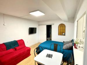sala de estar con sofá rojo y mesa en ~ le Terracotta ~ Studio 1/4 pers / Futuroscope, en Chasseneuil-du-Poitou