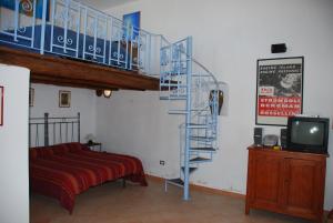 a spiral staircase in a room with a bed and a tv at Casa Particular Lipari in Lipari