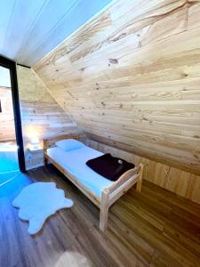 a room with a bed in a wooden wall at La cabane au pied des pistes in Chastreix