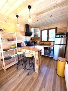 eine Küche mit einer Theke und Stühlen in einer Hütte in der Unterkunft La cabane au pied des pistes in Chastreix