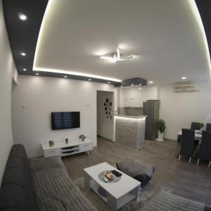 Apartman Amor Trebinje في تريبينيي: غرفة معيشة مع أريكة وطاولة
