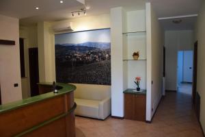 un vestíbulo con una zona de espera con una pintura en la pared en Hotel Il boschetto en Tolentino
